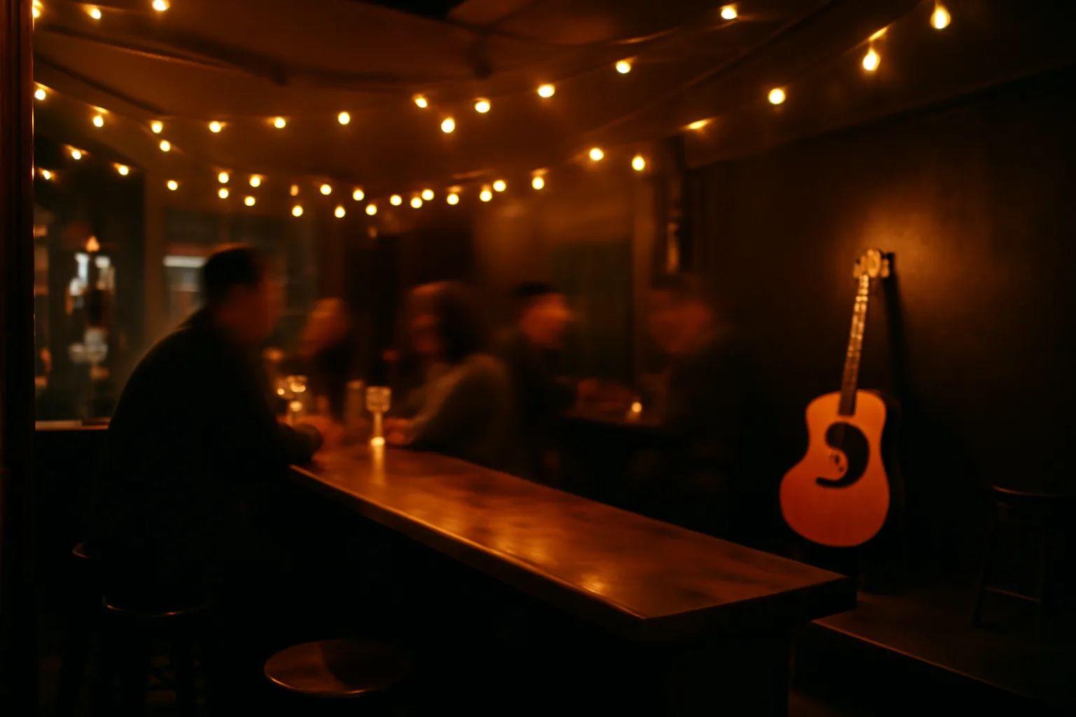 Dimly lit bar interior with small music stage, illustrating do bars need a license to play music
